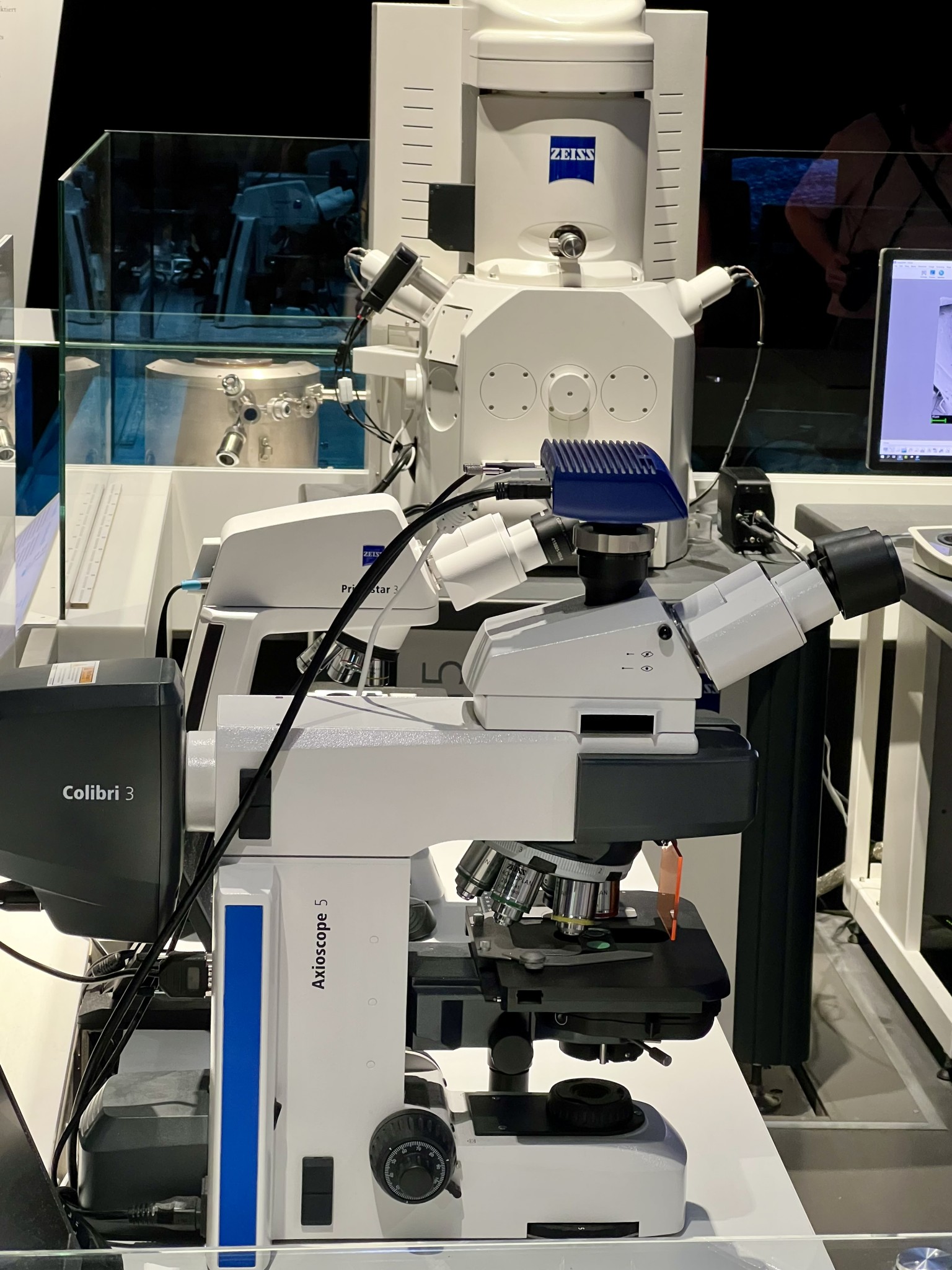 Vorne Lichtmikroskop, im Hintergrund Elektronenmikroskop